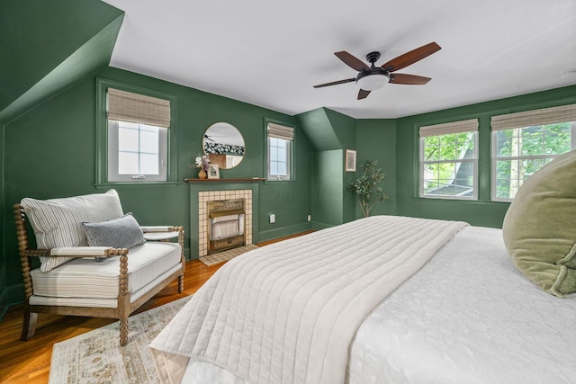 137 E Torrence Rd, Columbus, OH 43214 - bedroom with multiple windows, a tile fireplace, ceiling fan, and wood finished floors