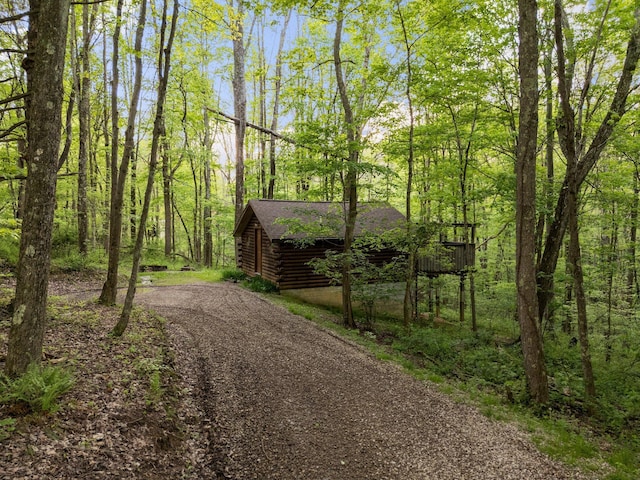 26975 Chapel Ridge Rd, South Bloomingville, OH 43152 - view of front of property with log siding, dirt driveway, a forest view, and roof with shingles