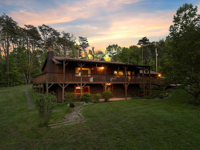 26975 Chapel Ridge Rd, South Bloomingville, OH 43152 - back of house at dusk with a deck, a lawn, and a chimney