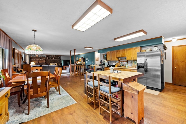 26975 Chapel Ridge Rd, South Bloomingville, OH 43152 - kitchen with stainless steel refrigerator with ice dispenser, light wood finished floors, decorative light fixtures, a textured ceiling, and crown molding