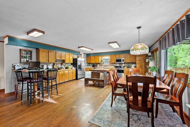 26975 Chapel Ridge Rd, South Bloomingville, OH 43152 - dining space featuring light wood-style flooring, a textured ceiling, and ornamental molding