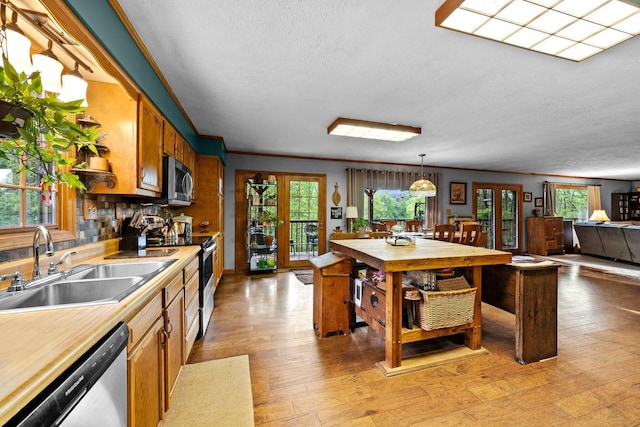 26975 Chapel Ridge Rd, South Bloomingville, OH 43152 - kitchen with stainless steel appliances, a sink, light wood-style floors, ornamental molding, and brown cabinetry