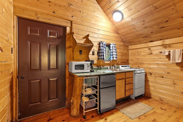 26975 Chapel Ridge Rd, South Bloomingville, OH 43152 - kitchen featuring white appliances, vaulted ceiling, light wood-type flooring, wooden walls, and dark countertops