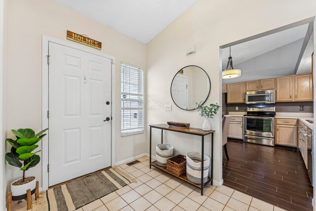 6389 Riverstone Dr, Columbus, OH 43228 - foyer with vaulted ceiling, baseboards, and light wood-style flooring