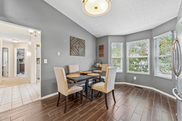 6389 Riverstone Dr, Columbus, OH 43228 - dining space featuring baseboards, vaulted ceiling, wood tiled floors, a textured ceiling, and a chandelier
