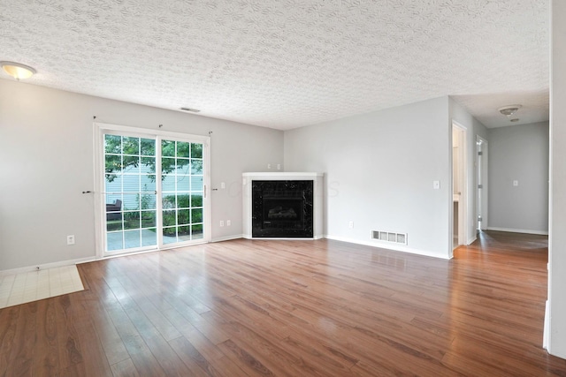 4655 Parrau Dr Unit 66A, Columbus, OH 43228 - unfurnished living room featuring wood finished floors, a textured ceiling, baseboards, and a fireplace