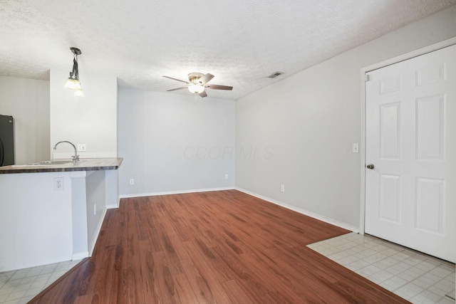 4655 Parrau Dr Unit 66A, Columbus, OH 43228 - unfurnished living room featuring a sink, a ceiling fan, wood finished floors, a textured ceiling, and baseboards
