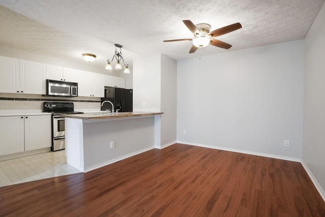 4655 Parrau Dr Unit 66A, Columbus, OH 43228 - kitchen featuring appliances with stainless steel finishes, white cabinetry, decorative backsplash, light countertops, and a ceiling fan