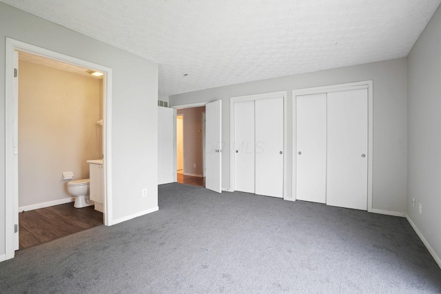 4655 Parrau Dr Unit 66A, Columbus, OH 43228 - unfurnished bedroom with carpet floors, two closets, ensuite bathroom, baseboards, and a textured ceiling