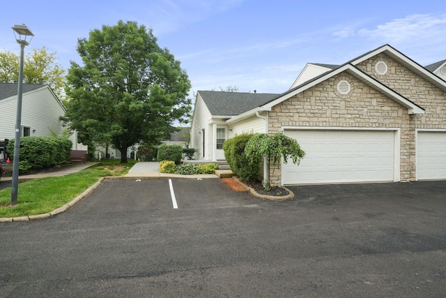 4655 Parrau Dr Unit 66A, Columbus, OH 43228 - view of front facade featuring stone siding, roof with shingles, and driveway