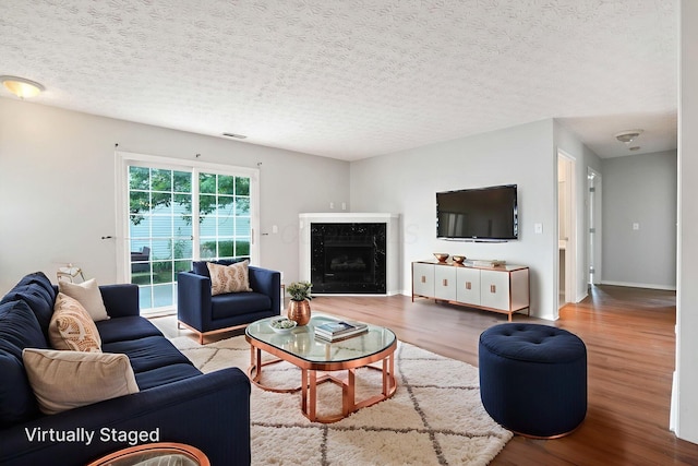 4655 Parrau Dr Unit 66A, Columbus, OH 43228 - living area featuring wood finished floors, a textured ceiling, a premium fireplace, and baseboards