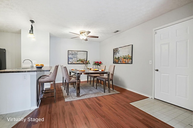 4655 Parrau Dr Unit 66A, Columbus, OH 43228 - dining room featuring wood finished floors, a ceiling fan, baseboards, and a textured ceiling