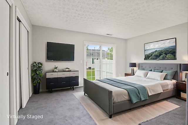 4655 Parrau Dr Unit 66A, Columbus, OH 43228 - bedroom featuring light colored carpet, access to exterior, and a textured ceiling