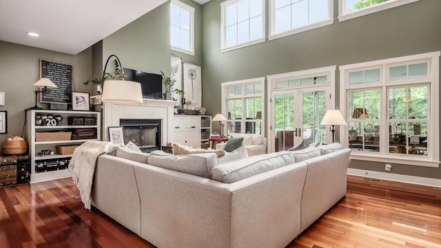 122 Boulder Ct, Granville, OH 43023 - living room featuring a fireplace, hardwood / wood-style flooring, a high ceiling, baseboards, and recessed lighting