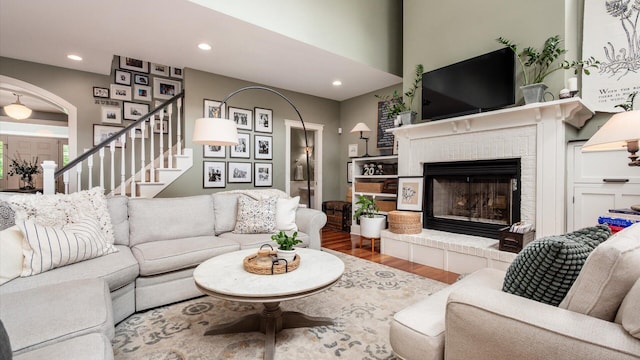 122 Boulder Ct, Granville, OH 43023 - living room featuring wood finished floors, a brick fireplace, recessed lighting, and stairway