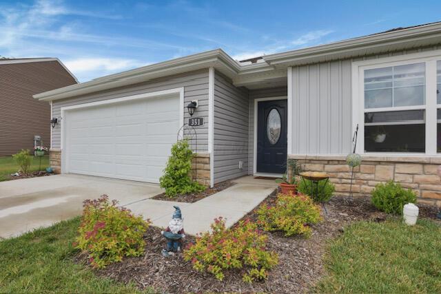 351 Trinity Way W, Newark, OH 43055 - doorway to property featuring board and batten siding, concrete driveway, stone siding, and a garage