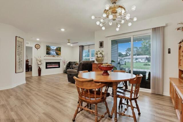 351 Trinity Way W, Newark, OH 43055 - dining room featuring a glass covered fireplace, light wood finished floors, a chandelier, and recessed lighting