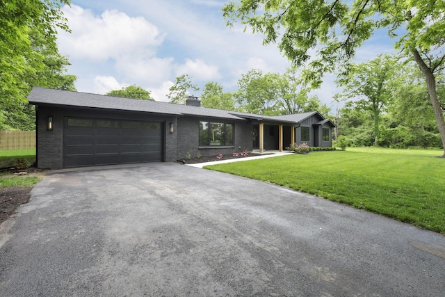 29 Pocono Rd, Columbus, OH 43235 - view of front of home featuring a chimney, asphalt driveway, an attached garage, and brick siding