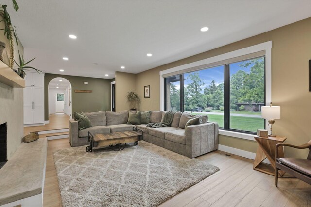 29 Pocono Rd, Columbus, OH 43235 - living area with arched walkways, light wood-style floors, recessed lighting, baseboards, and a fireplace with raised hearth