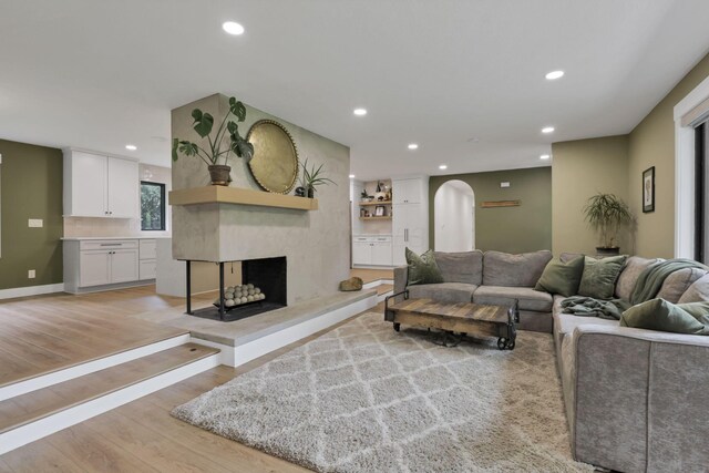 29 Pocono Rd, Columbus, OH 43235 - living room featuring arched walkways, a multi sided fireplace, recessed lighting, and light wood-style flooring