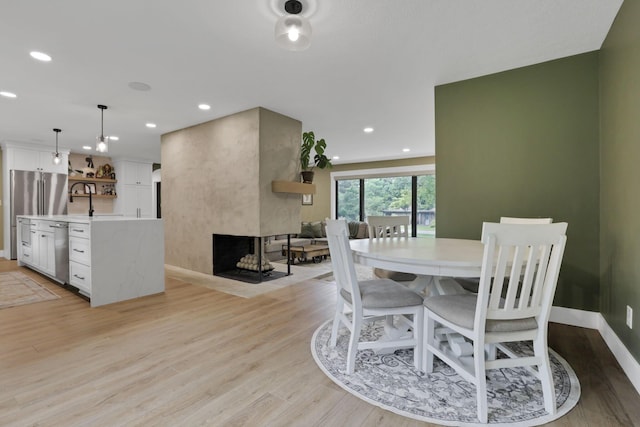 29 Pocono Rd, Columbus, OH 43235 - dining space with light wood-style flooring, baseboards, recessed lighting, and a multi sided fireplace