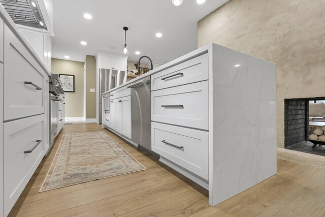 29 Pocono Rd, Columbus, OH 43235 - kitchen with white cabinets, light wood-style floors, recessed lighting, and hanging light fixtures