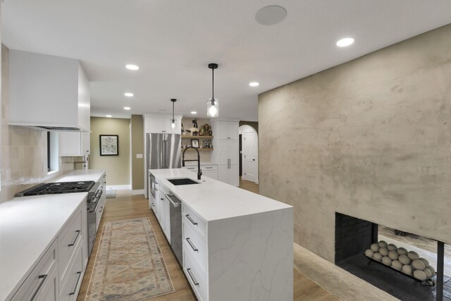 29 Pocono Rd, Columbus, OH 43235 - kitchen with a sink, stainless steel appliances, light wood-style flooring, recessed lighting, and white cabinetry