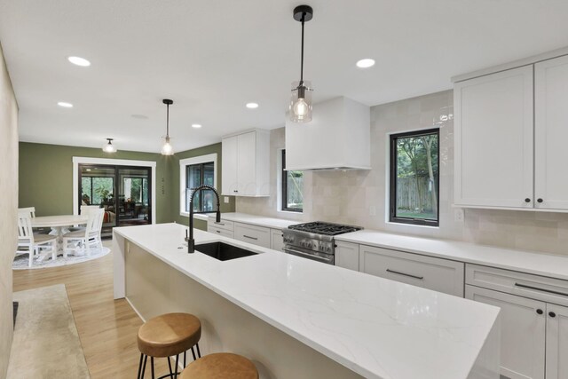 29 Pocono Rd, Columbus, OH 43235 - kitchen with a sink, high end range, light wood-style floors, backsplash, and recessed lighting
