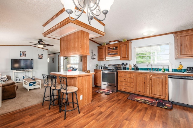 2389 Bluff Run Dr, Grove City, OH 43123 - kitchen featuring appliances with stainless steel finishes, a textured ceiling, open floor plan, lofted ceiling, and a kitchen bar