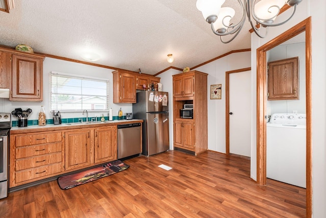 2389 Bluff Run Dr, Grove City, OH 43123 - kitchen with washer / clothes dryer, appliances with stainless steel finishes, ornamental molding, a sink, and dark wood-type flooring