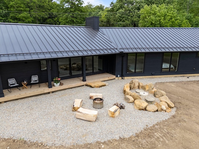 7931 Concord Rd, Johnstown, OH 43031 - back of house featuring a standing seam roof, an outdoor fire pit, a chimney, and a metal roof