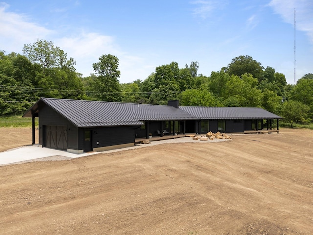 7931 Concord Rd, Johnstown, OH 43031 - view of front facade featuring a standing seam roof, a metal roof, a chimney, a detached garage, and dirt driveway