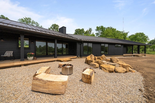 7931 Concord Rd, Johnstown, OH 43031 - back of property featuring a standing seam roof, a chimney, a metal roof, and a fire pit