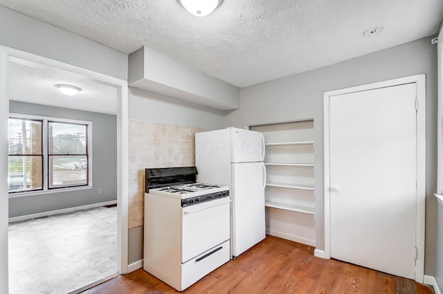 1011 Mcclelland Ave, Columbus, OH 43211 - kitchen featuring white appliances, light wood-type flooring, decorative backsplash, a textured ceiling, and baseboards