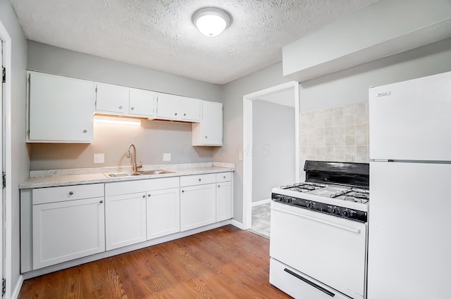 1011 Mcclelland Ave, Columbus, OH 43211 - kitchen with white appliances, a sink, white cabinets, light countertops, and light wood finished floors