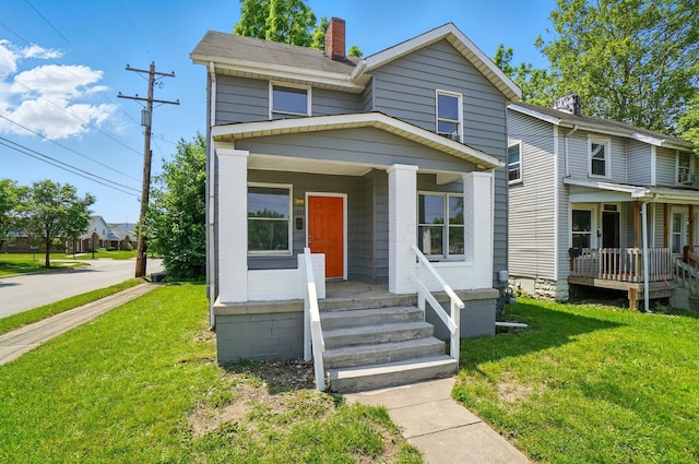 1011 Mcclelland Ave, Columbus, OH 43211 - view of front facade with a porch, a chimney, and a front lawn