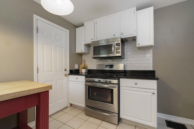 966 Chambers Cir, Columbus, OH 43212 - kitchen with appliances with stainless steel finishes, white cabinets, decorative backsplash, and light tile patterned flooring