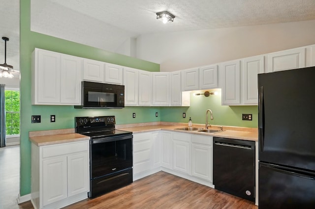 418 Broadview Ct, Pataskala, OH 43062 - kitchen featuring black appliances, lofted ceiling, a sink, white cabinets, and light countertops