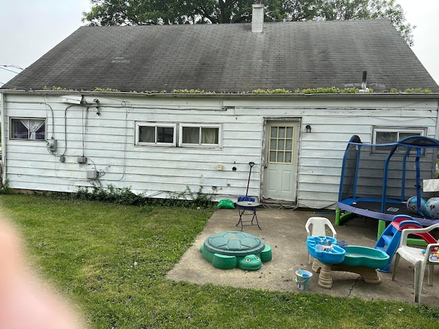 803 Demorest Rd, Columbus, OH 43204 - rear view of property with a trampoline, a yard, a chimney, and a patio