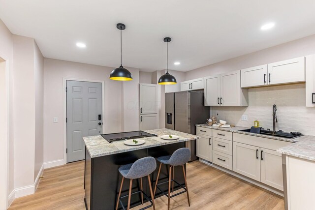 72 Avondale Ave, Columbus, OH 43222 - kitchen featuring stovetop, tasteful backsplash, a center island, light wood-style flooring, and recessed lighting