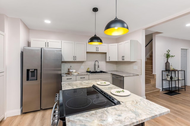 72 Avondale Ave, Columbus, OH 43222 - kitchen with appliances with stainless steel finishes, light wood-style flooring, backsplash, white cabinets, and recessed lighting