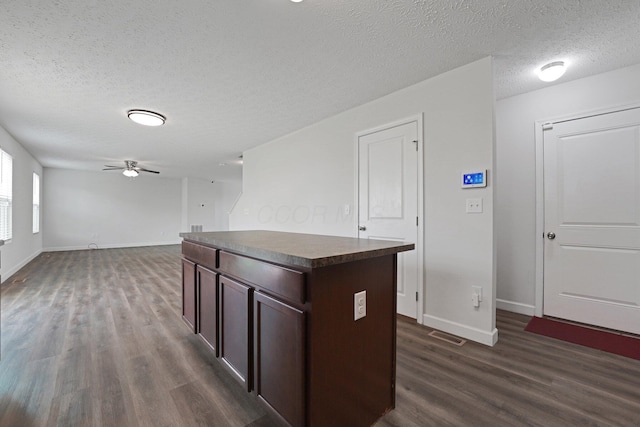 2576 Brook Run Dr, Lancaster, OH 43130 - kitchen featuring dark wood-type flooring, dark countertops, baseboards, a center island, and a textured ceiling