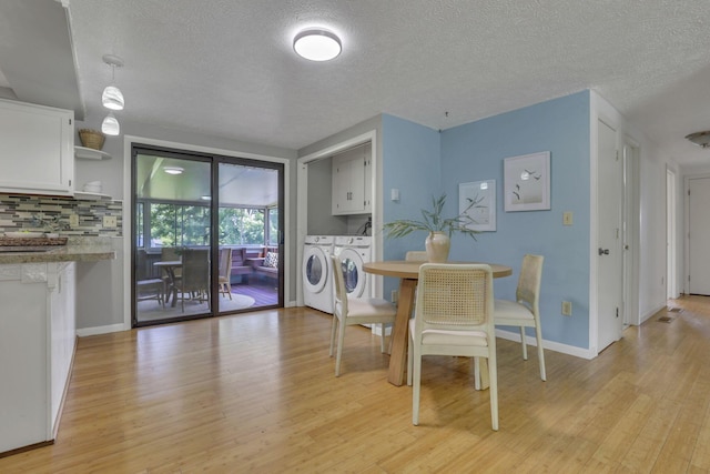 4476 Stiving Rd, Shelby, OH 44875 - dining area featuring washer and dryer, light wood-style floors, and a textured ceiling
