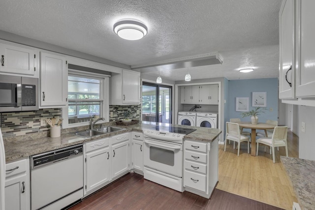 4476 Stiving Rd, Shelby, OH 44875 - kitchen featuring white appliances, washing machine and dryer, a textured ceiling, a peninsula, and white cabinetry