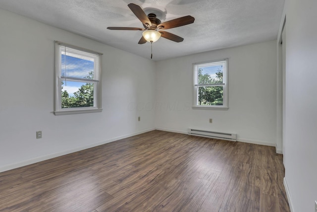 4476 Stiving Rd, Shelby, OH 44875 - empty room featuring baseboard heating, healthy amount of natural light, wood finished floors, and a textured ceiling
