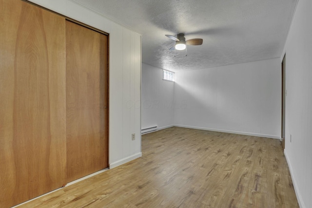 4476 Stiving Rd, Shelby, OH 44875 - spare room with a baseboard heating unit, a textured ceiling, wood finished floors, and a ceiling fan