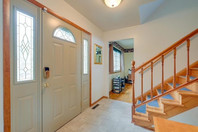4909 Vanlear Rd, Columbus, OH 43229 - foyer featuring light tile patterned floors, stairs, and baseboards