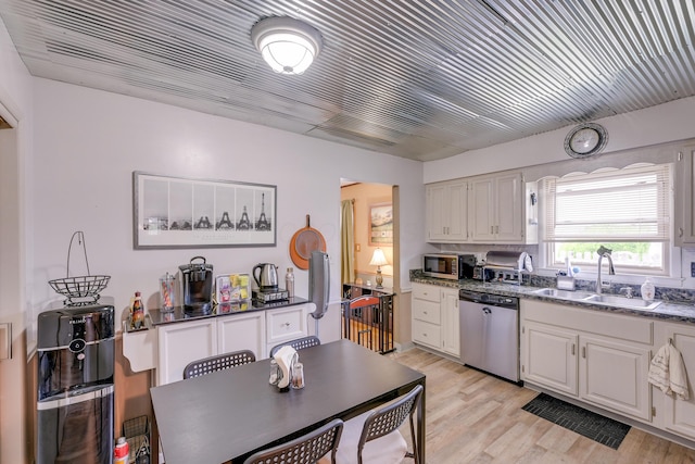 4909 Vanlear Rd, Columbus, OH 43229 - kitchen with stainless steel appliances, a sink, white cabinetry, and light wood-style flooring