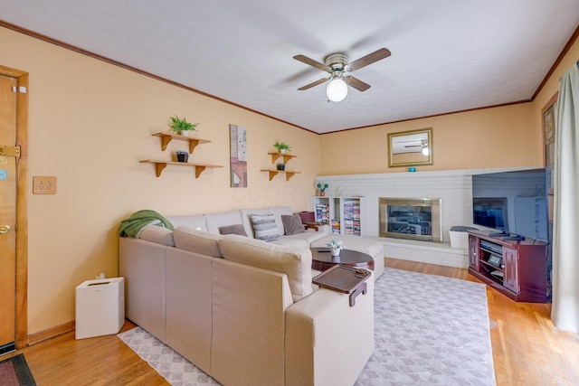 4909 Vanlear Rd, Columbus, OH 43229 - living room featuring wood finished floors, ceiling fan, a brick fireplace, and ornamental molding