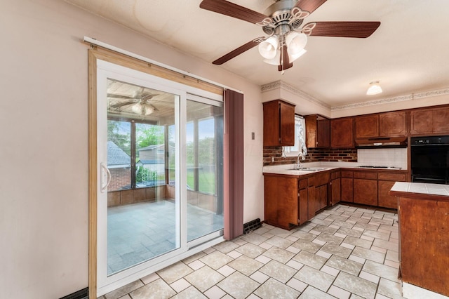 5045 Labelle Dr, Columbus, OH 43232 - kitchen with ceiling fan, backsplash, under cabinet range hood, a sink, and tile counters